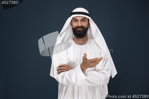 Image of Arabian saudi businessman on dark blue studio background