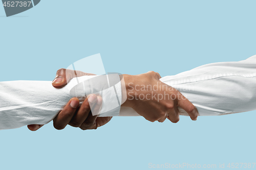 Image of Male hands demonstrating a gesture of holding and strong isolated on blue studio background.