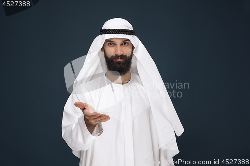 Image of Arabian saudi businessman on dark blue studio background