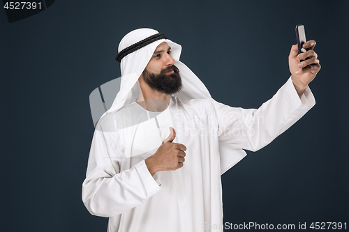 Image of Arabian saudi man on dark blue studio background