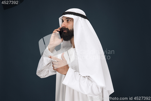 Image of Arabian saudi man on dark blue studio background