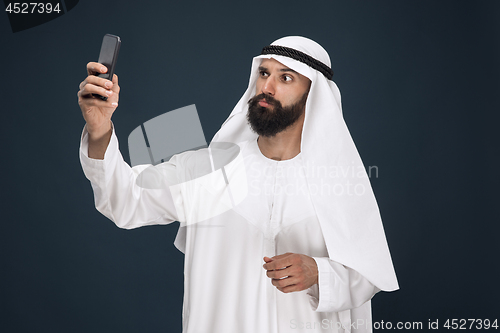 Image of Arabian saudi man on dark blue studio background