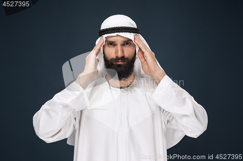 Image of Arabian saudi man on dark blue studio background