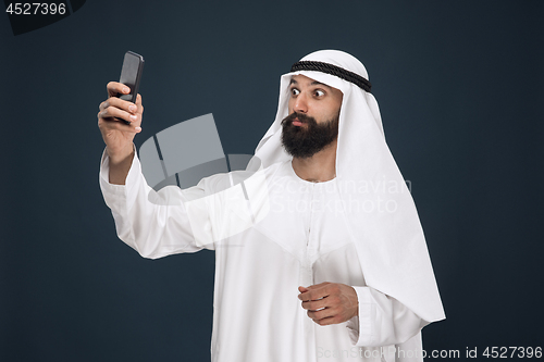 Image of Arabian saudi man on dark blue studio background