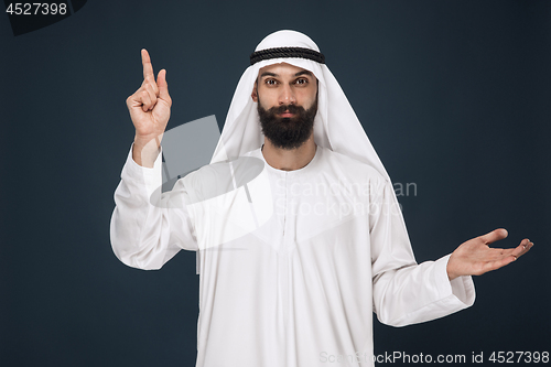 Image of Arabian saudi man on dark blue studio background