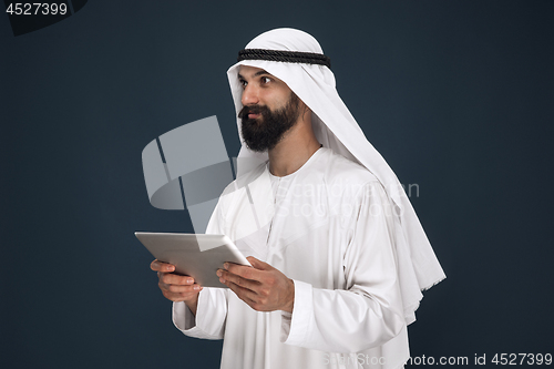 Image of Arabian saudi businessman on dark blue studio background