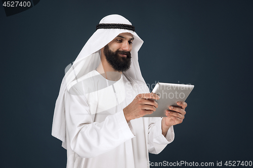 Image of Arabian saudi businessman on dark blue studio background