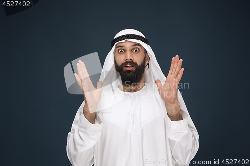 Image of Arabian saudi man on dark blue studio background