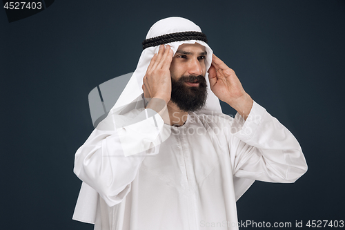 Image of Arabian saudi man on dark blue studio background