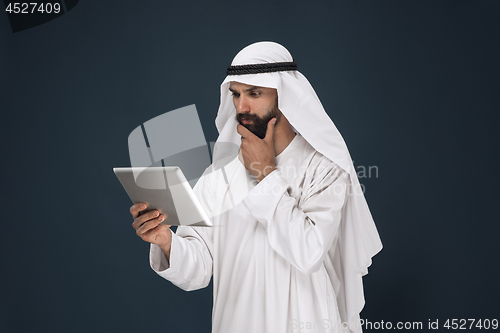 Image of Arabian saudi businessman on dark blue studio background