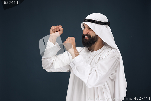 Image of Arabian saudi man on dark blue studio background