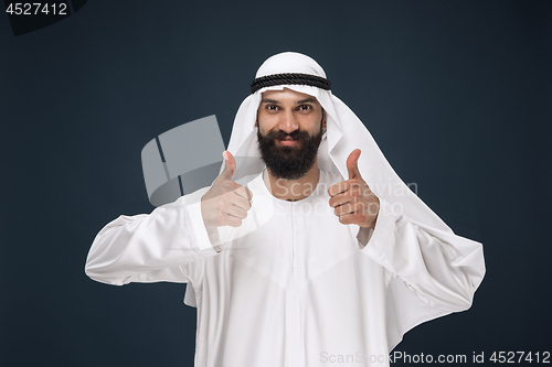 Image of Arabian saudi man on dark blue studio background