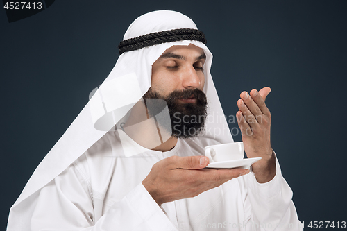 Image of Arabian saudi man on dark blue studio background