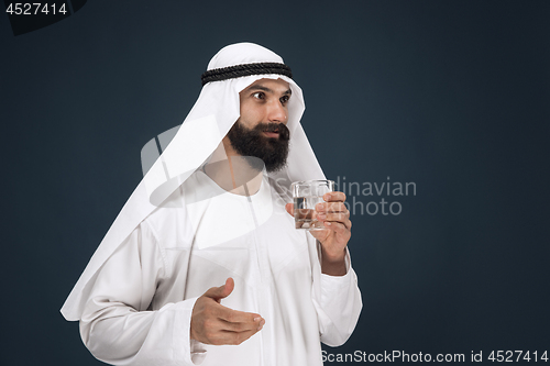 Image of Arabian saudi man on dark blue studio background