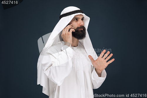 Image of Arabian saudi man on dark blue studio background