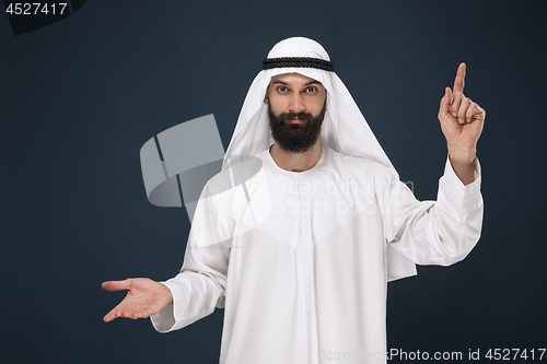 Image of Arabian saudi man on dark blue studio background