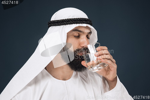 Image of Arabian saudi man on dark blue studio background