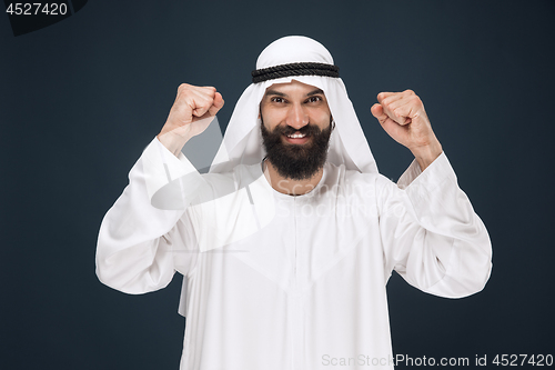 Image of Arabian saudi man on dark blue studio background