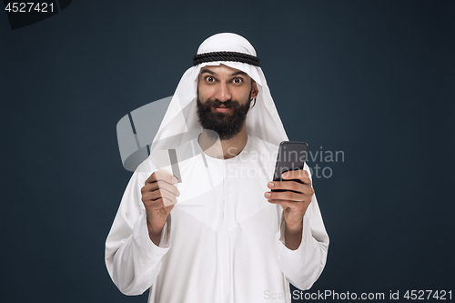 Image of Arabian saudi man on dark blue studio background