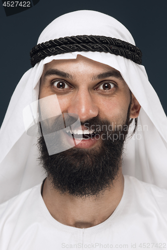 Image of Arabian saudi man on dark blue studio background