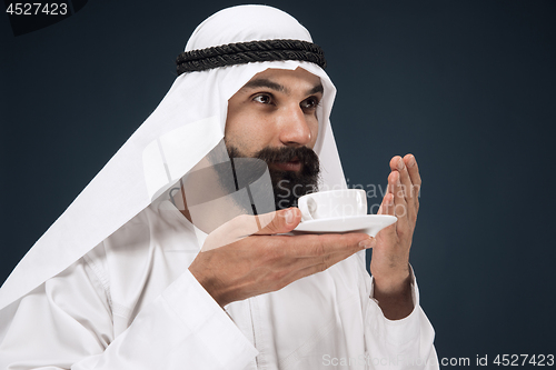 Image of Arabian saudi man on dark blue studio background