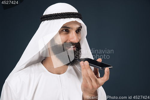 Image of Arabian saudi man on dark blue studio background