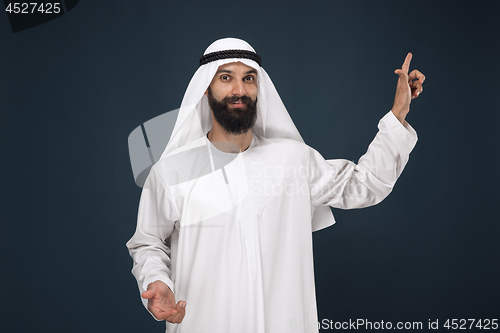 Image of Arabian saudi man on dark blue studio background