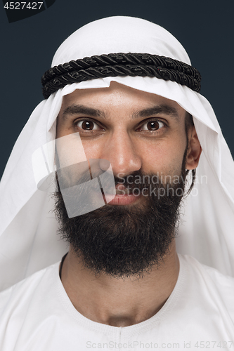 Image of Arabian saudi man on dark blue studio background