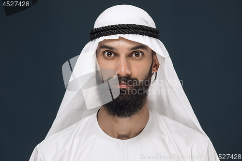 Image of Arabian saudi man on dark blue studio background