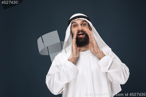 Image of Arabian saudi man on dark blue studio background