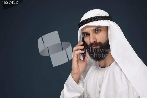 Image of Arabian saudi man on dark blue studio background