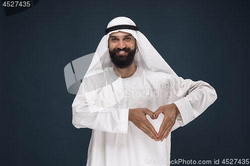 Image of Arabian saudi man on dark blue studio background