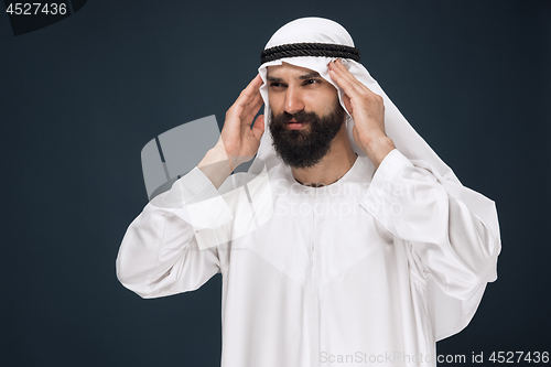 Image of Arabian saudi man on dark blue studio background