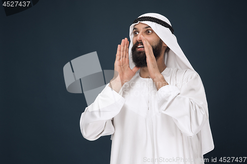 Image of Arabian saudi man on dark blue studio background