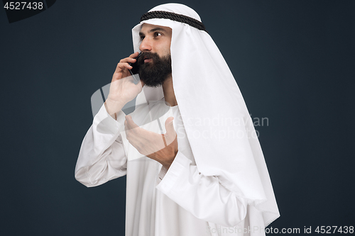 Image of Arabian saudi man on dark blue studio background