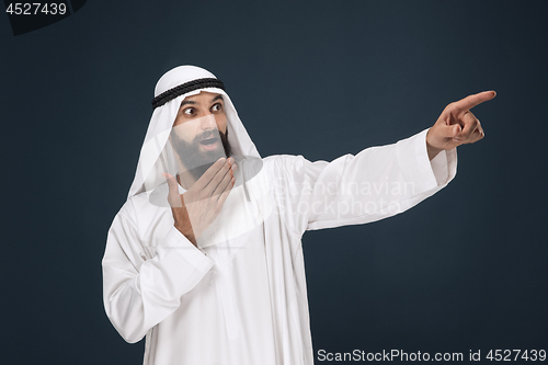 Image of Arabian saudi businessman on dark blue studio background