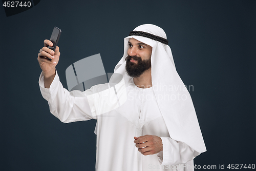 Image of Arabian saudi man on dark blue studio background