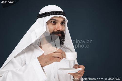 Image of Arabian saudi man on dark blue studio background