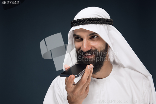 Image of Arabian saudi man on dark blue studio background