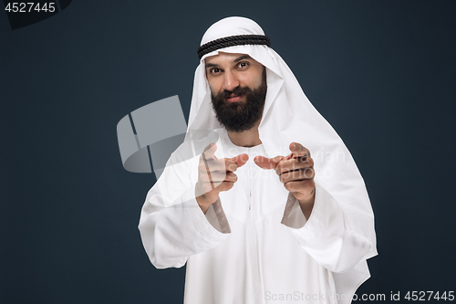 Image of Arabian saudi businessman on dark blue studio background