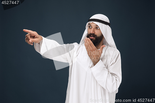 Image of Arabian saudi businessman on dark blue studio background