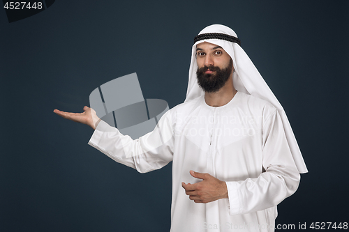 Image of Arabian saudi man on dark blue studio background