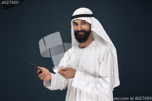 Image of Arabian saudi man on dark blue studio background