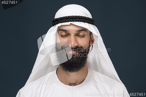 Image of Arabian saudi man on dark blue studio background