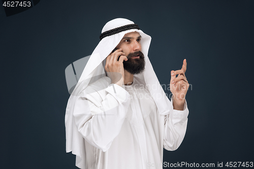 Image of Arabian saudi man on dark blue studio background