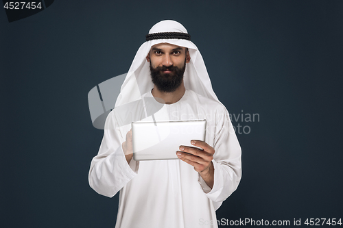 Image of Arabian saudi businessman on dark blue studio background