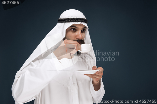 Image of Arabian saudi man on dark blue studio background