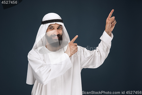 Image of Arabian saudi businessman on dark blue studio background