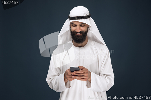 Image of Arabian saudi man on dark blue studio background