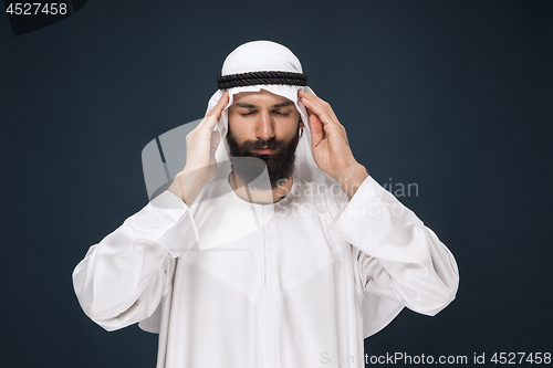 Image of Arabian saudi man on dark blue studio background